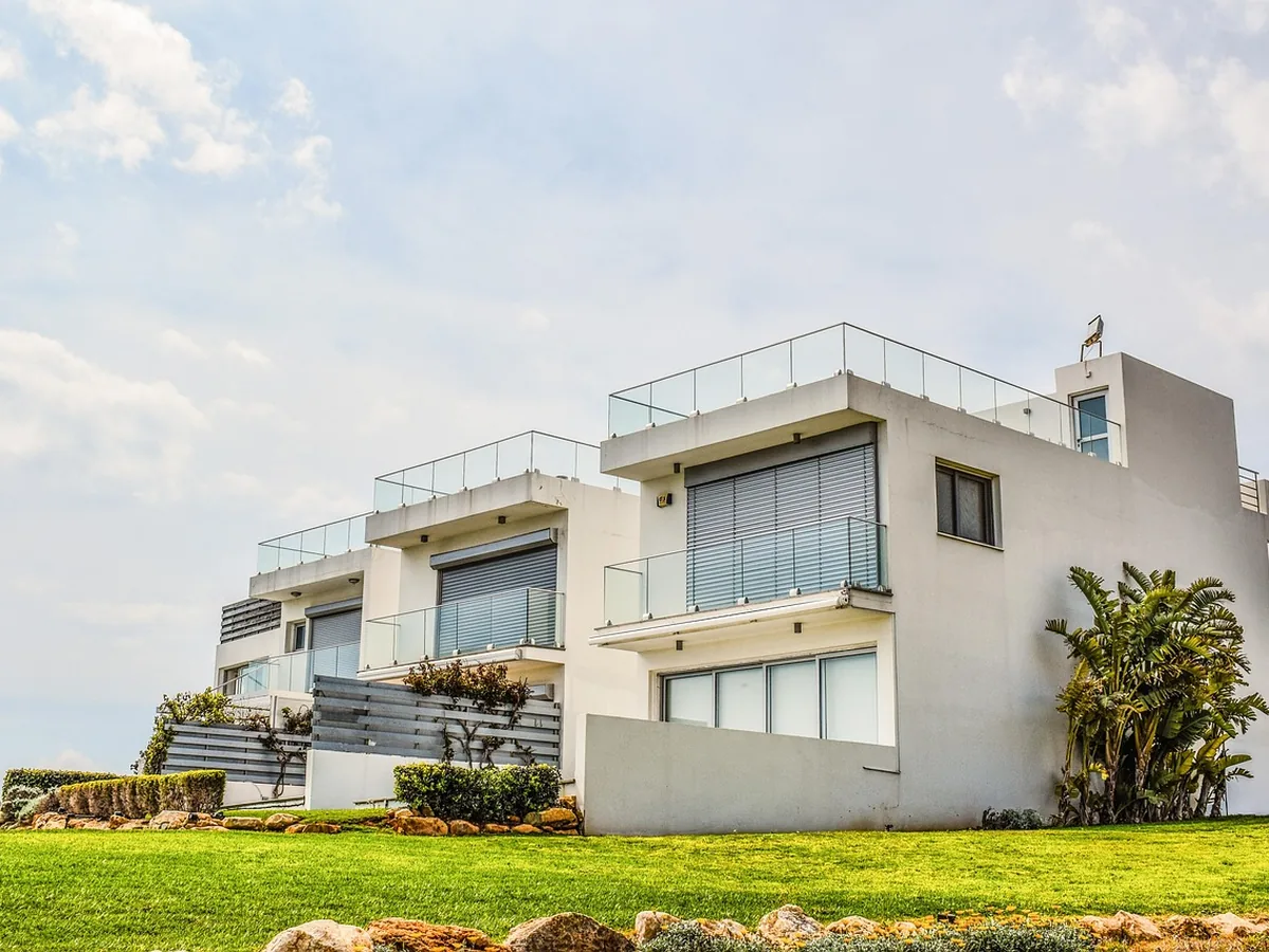 Casa moderna de dois andares com jardim, exemplo de imóvel protegido por seguro residencial